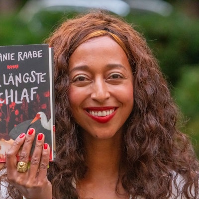 Die Autorin hält das Buch hoch.