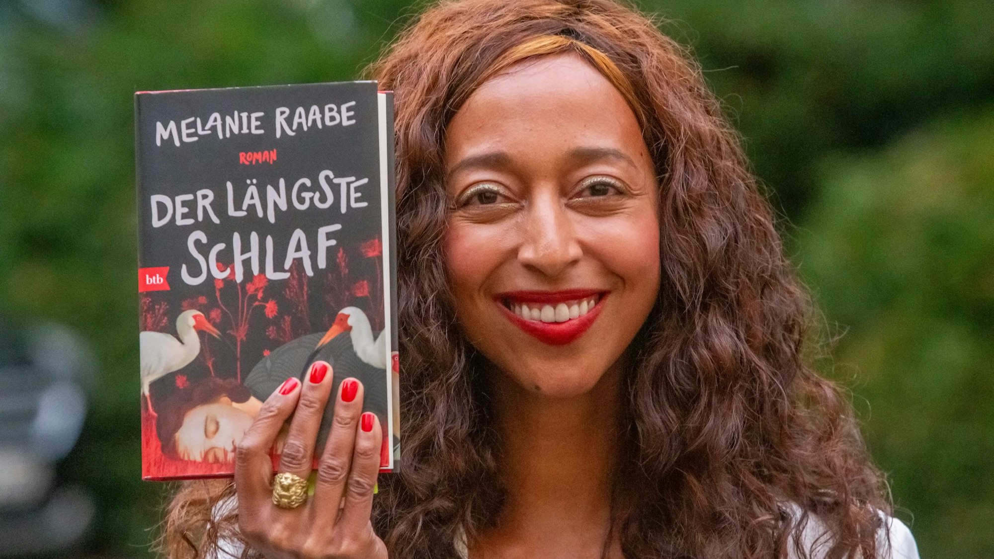 Die Autorin hält das Buch hoch.