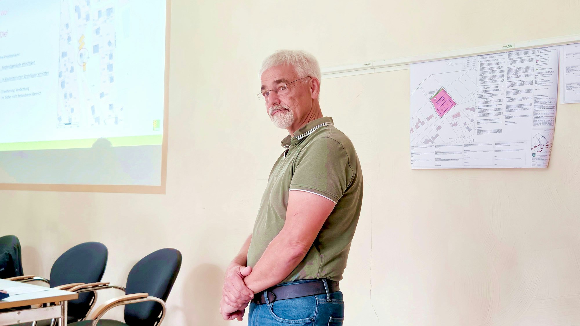 Das Bild zeigt Heinz Frey, der mit verschränkten Armen vor einer Wand steht.