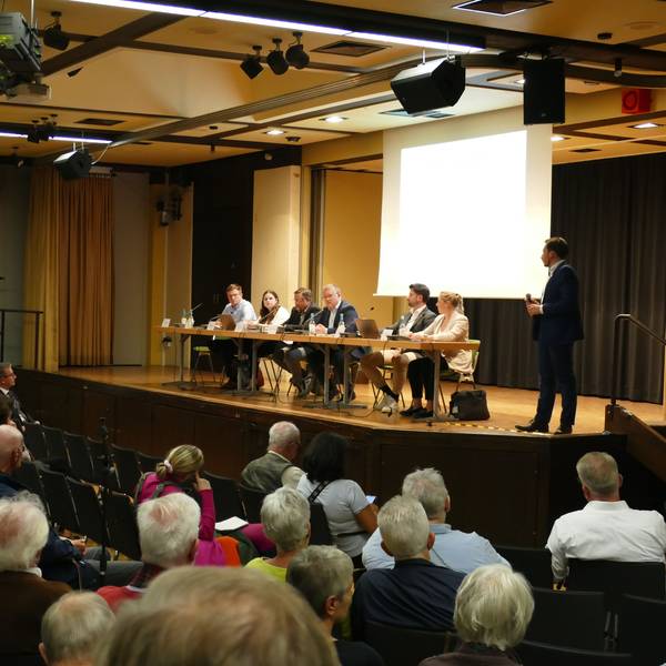 In der Aula der Alfred-Delp-Realschule in Niederkassel sitzen bei einer Informationsveranstaltung zur geplanten ZUE rund 300 Besucher.