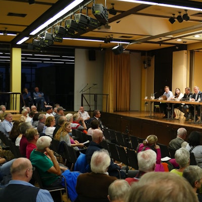 In der Aula der Alfred-Delp-Realschule in Niederkassel sitzen bei einer Informationsveranstaltung zur geplanten ZUE rund 300 Besucher.