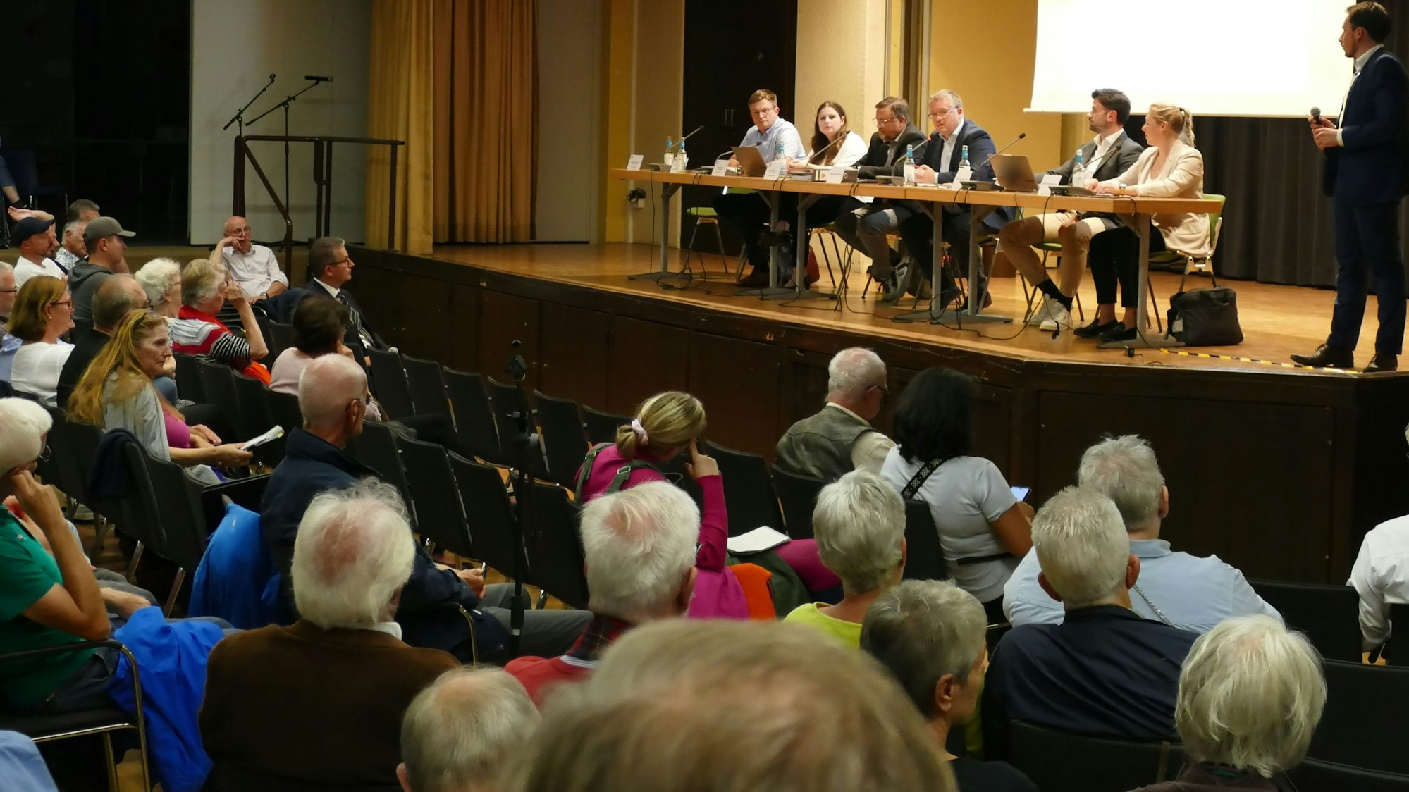 In der Aula der Alfred-Delp-Realschule in Niederkassel sitzen bei einer Informationsveranstaltung zur geplanten ZUE rund 300 Besucher.