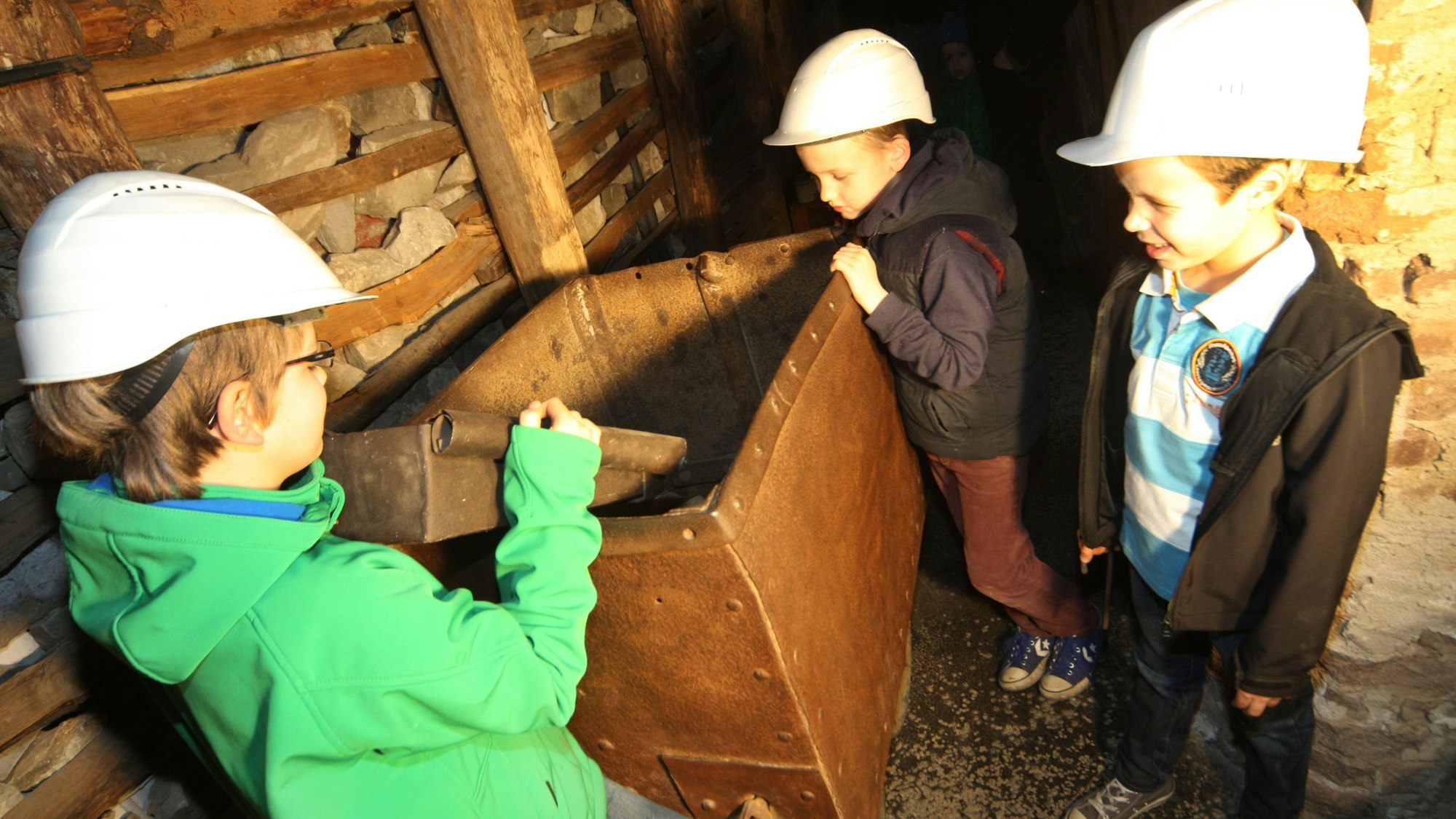 Kinder stehen an einem Förderwagen im Schaubergwerk des Bergischen Museums für Bergbau, Handwerk und Gewerbe.