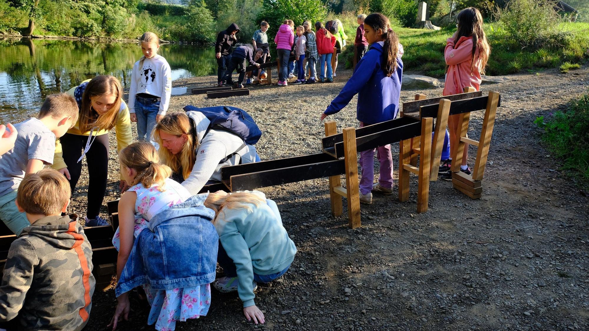 Kinder spielen mit einer Wasserbahn