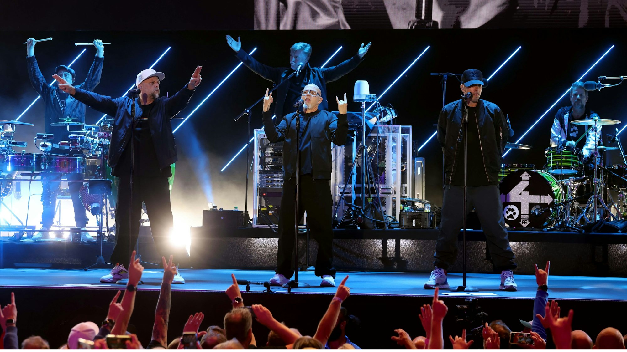 Die Fantastischen Vier stehen in schwarzen Outfits auf der Bühne.