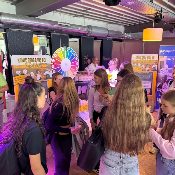 Das Bild zeigt mehrere Schülerinnen an Informationsständen.
