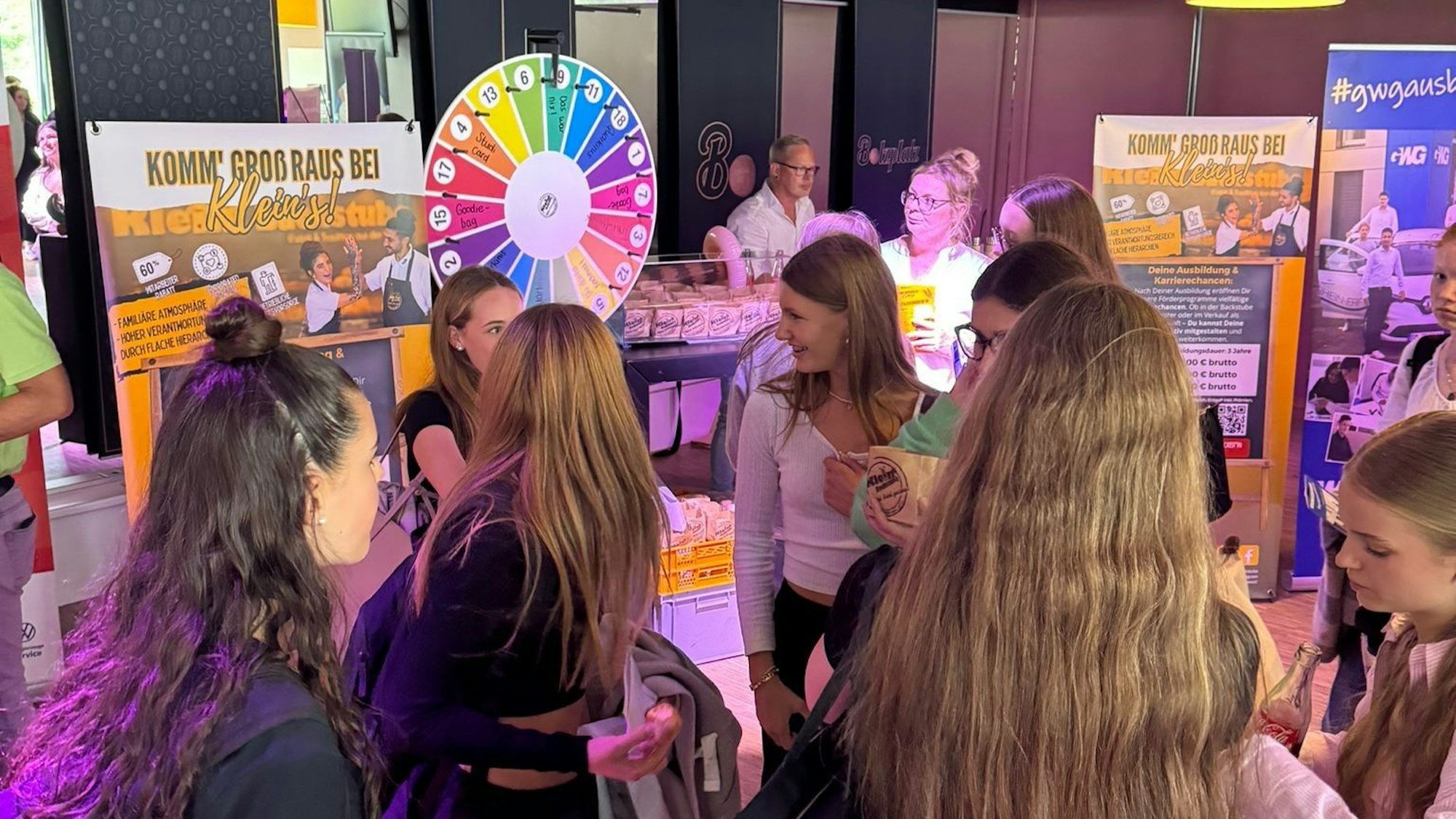 Das Bild zeigt mehrere Schülerinnen an Informationsständen.