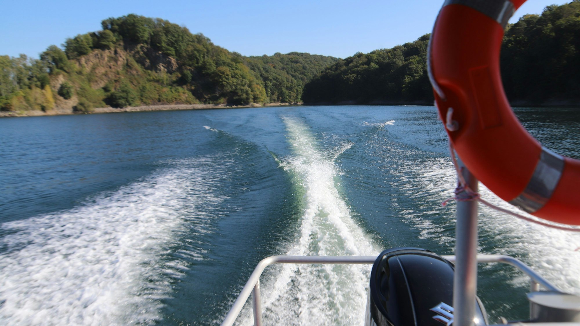 Ein Boot ziet eine Heckwelle hinter sich her.