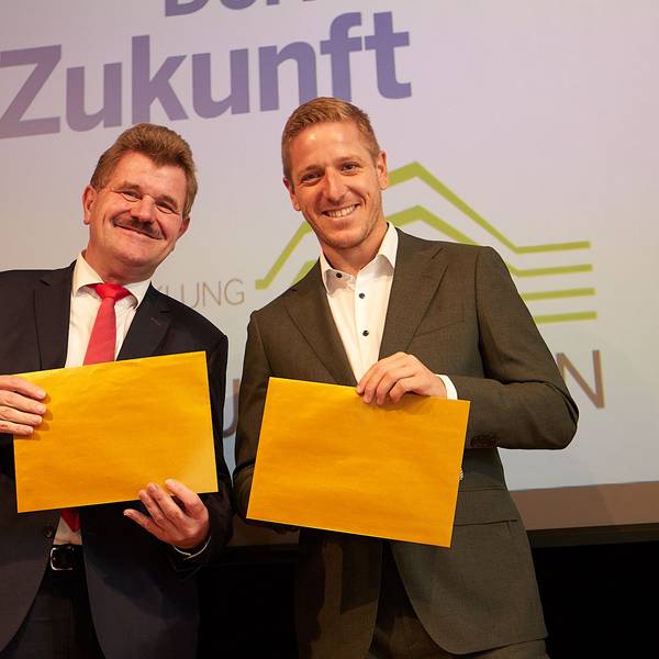 Karl-Heinz Daniels und Markus Ramers hatten die goldfarbenen Umschläge, in denen die Namen der neuen Golddörfer waren, in den Händen.
