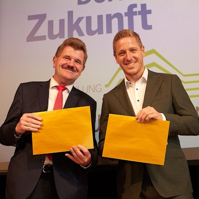 Karl-Heinz Daniels und Markus Ramers hatten die goldfarbenen Umschläge, in denen die Namen der neuen Golddörfer waren, in den Händen.