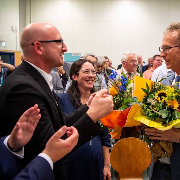 Ingo Pfennings steht neben Detlef Seif, der einen Blumenstrauß in der Hand hält.
