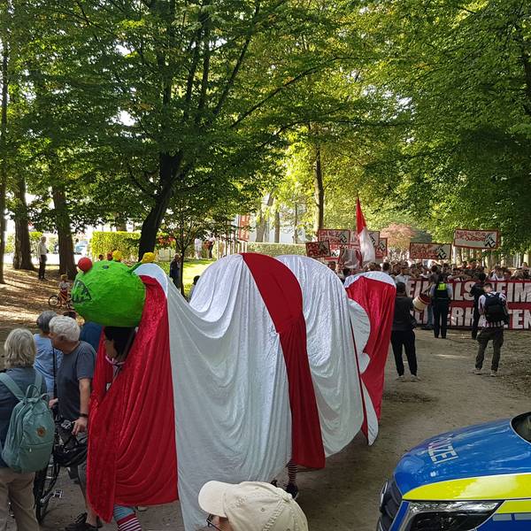 Protest der Bürgerinitiative Grüngürtel für Alle am Geißbockheim gegen den Bau des Jugendleistungszentrums.
Im Hintergrund stören etwa 150 Ultras durch Gesänge den Spaziergang der Ausbaugegner.
