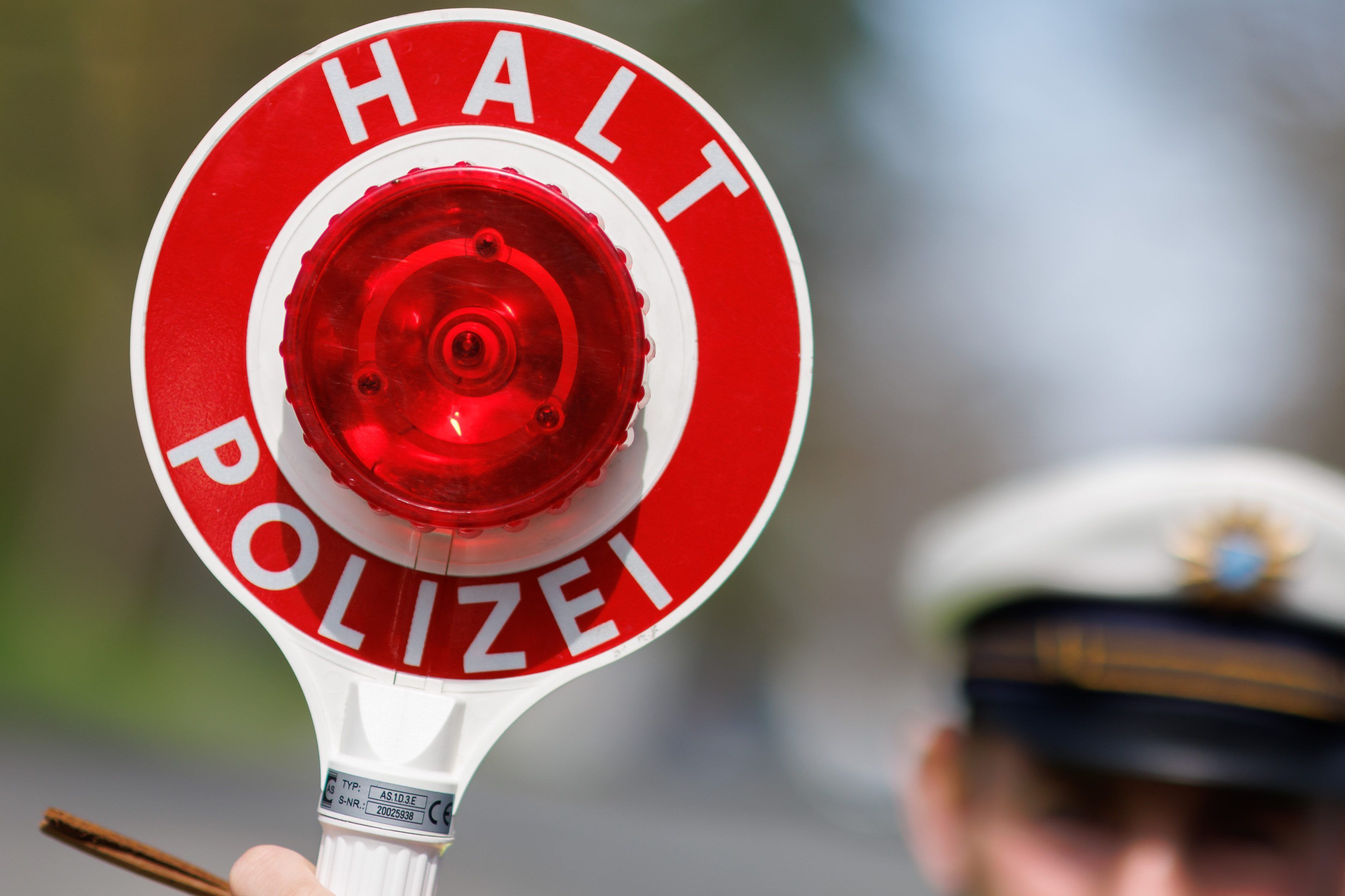Ein Polizist zieht ein Fahrzeug mit seiner Kelle aus dem Verkehr.
