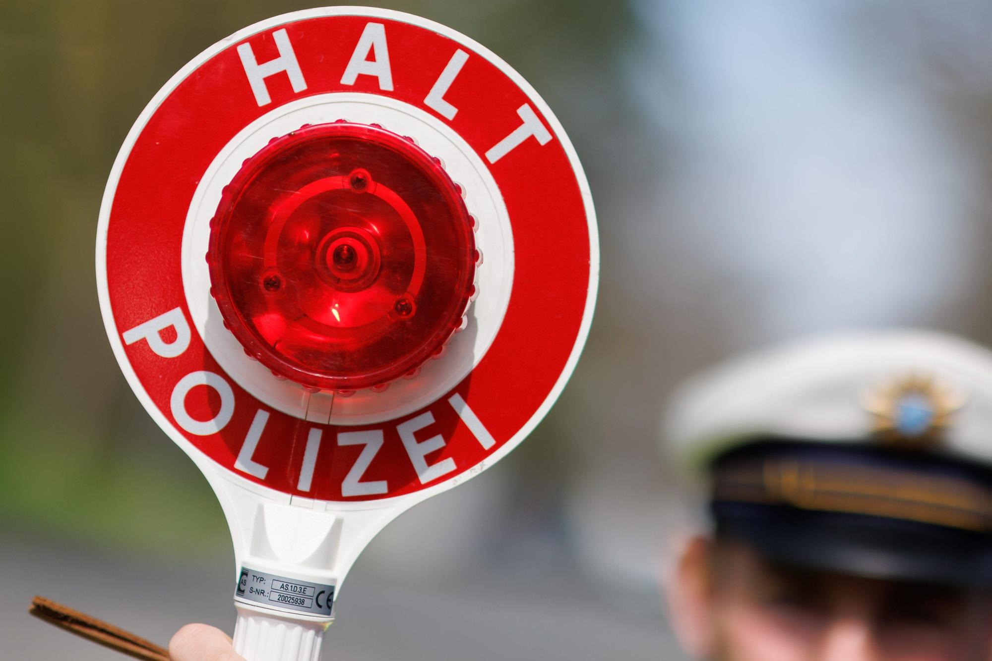 Ein Polizist zieht ein Fahrzeug mit seiner Kelle aus dem Verkehr.