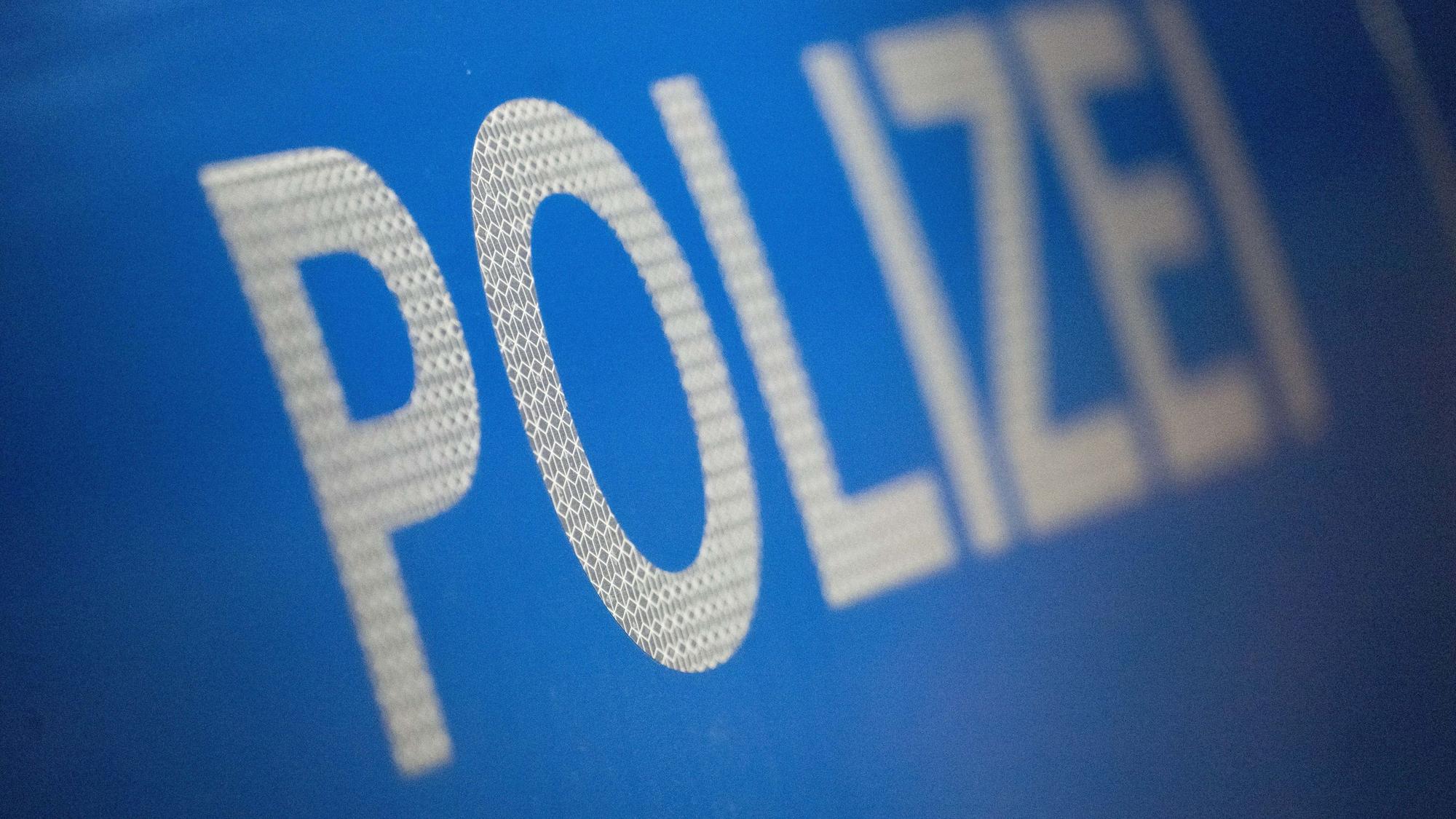 Das Wort Polizei ist auf der Karosserie eines Polizeifahrzeugs zu sehen.