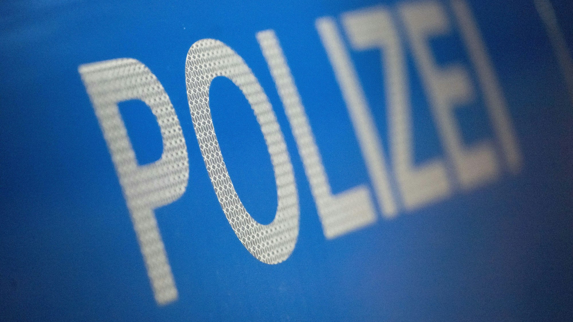 Das Wort Polizei ist auf der Karosserie eines Polizeifahrzeugs zu sehen.