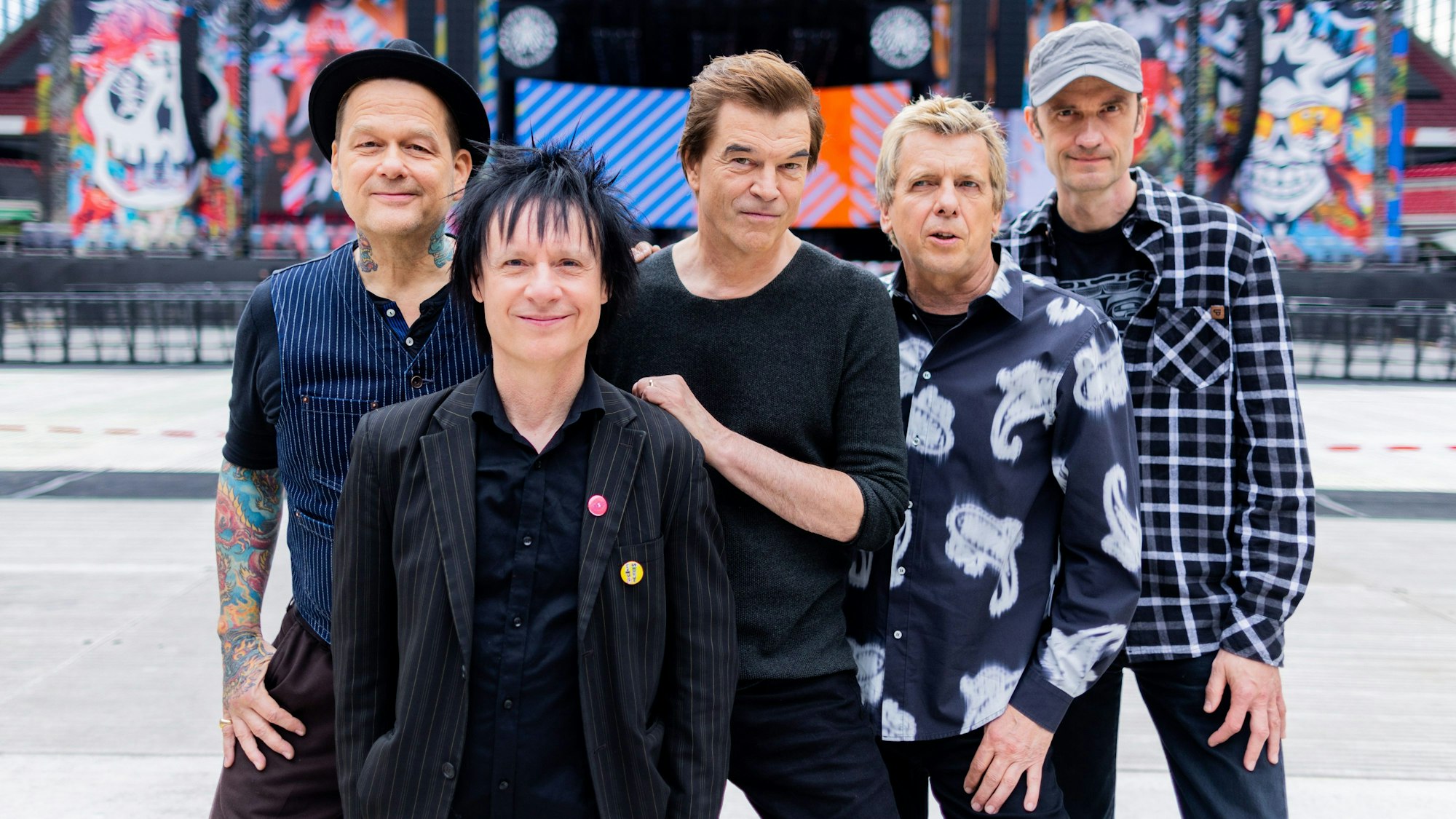 Campino (M, bürgerlich: Andreas Frege), Sänger der Punkband «Die Toten Hosen», Andreas von Holst (l, Kuddel), Michael Breitkopf (r, Breiti), Andreas Meurer (Andi) und Stephen George Ritchie (2.v.l. Vom Ritchie), stehen vor der Bühne im RheinEnergieStadion in Köln.