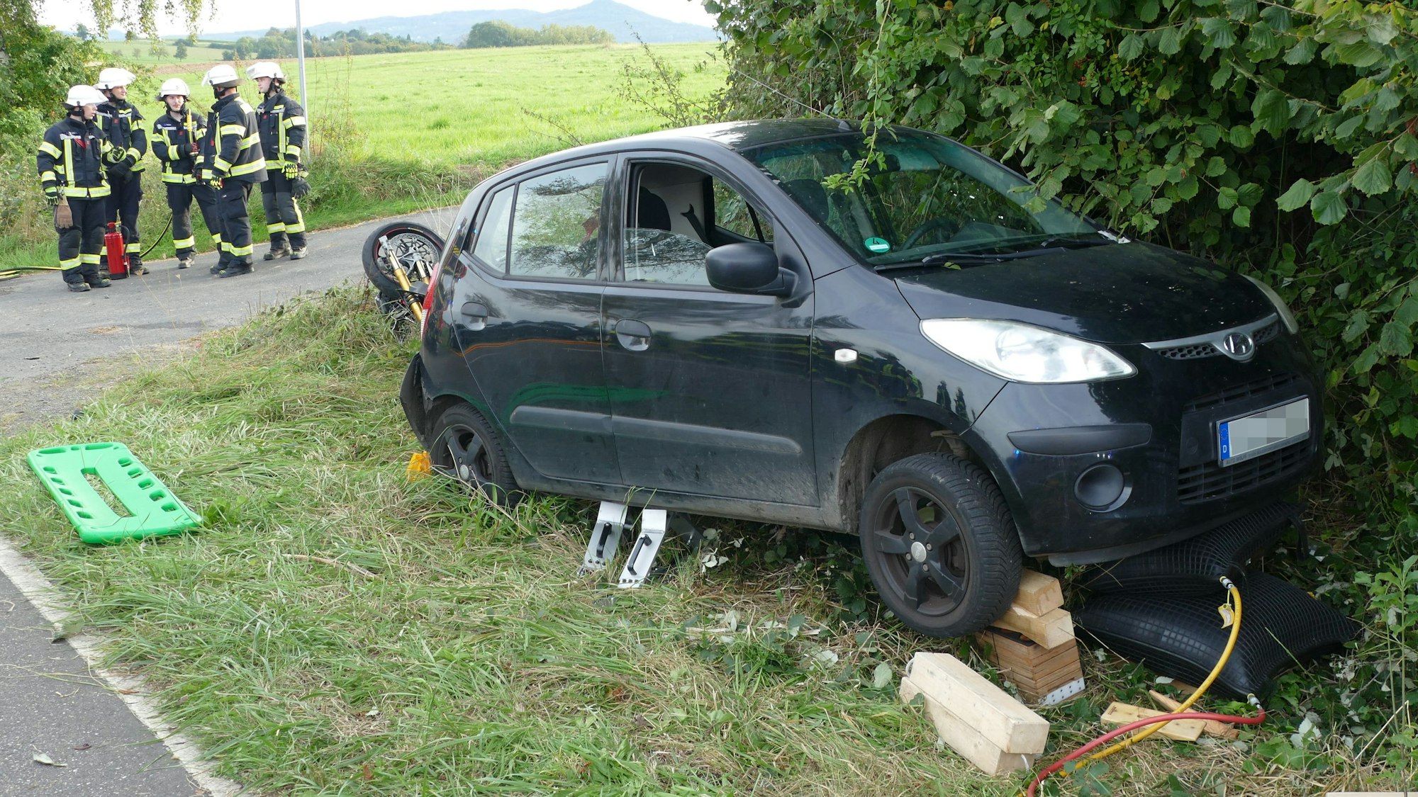 Ein Auto im Grünstreifen, das von Hebekissen aufgebockt wurde.