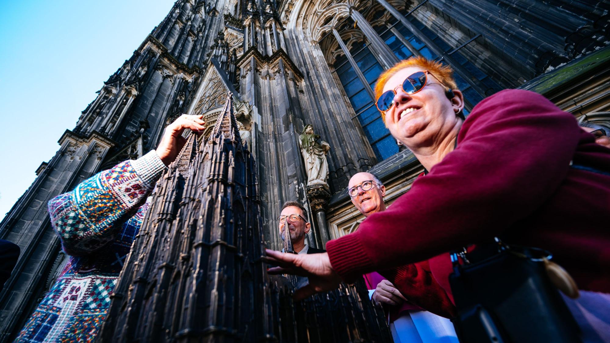 Andrea Eberl tastet als erste bei der Vorstellung des neuen Bronze-Modells am Kölner Dom.