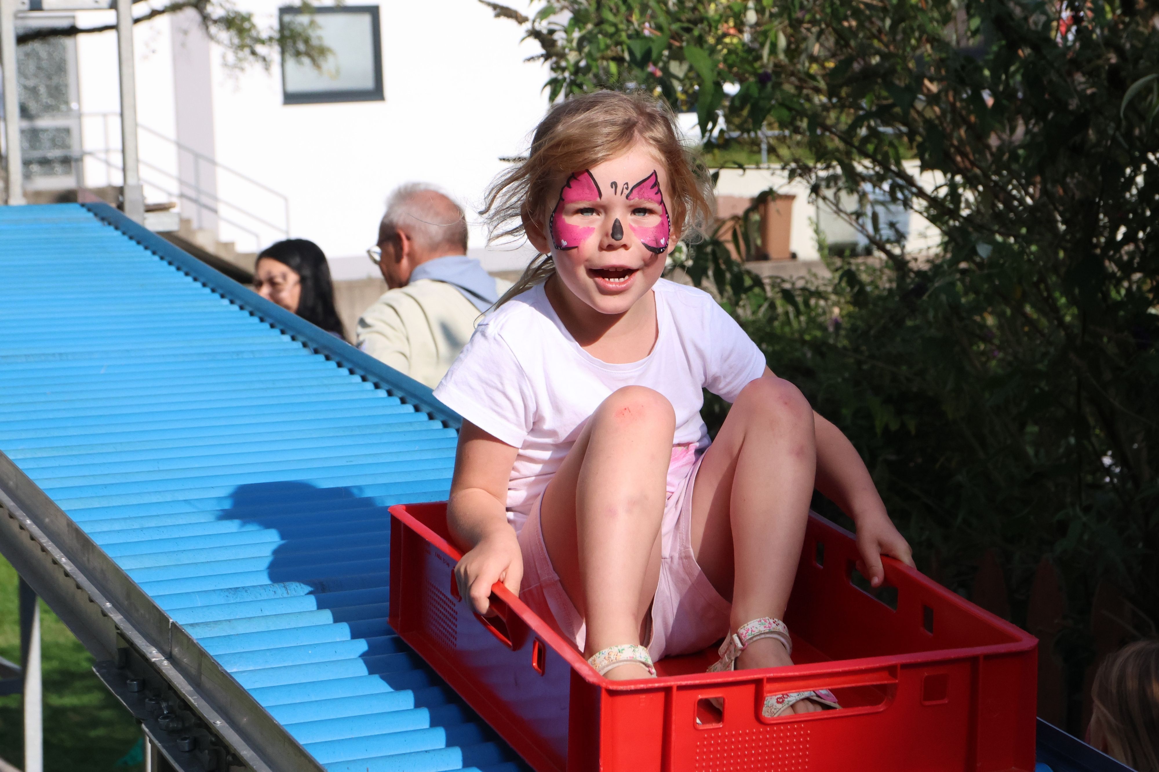 Einmal ist kein Mal: Die dreijährige Lisa genießt im Waldbröler Netzwerk-Garten rasante Fahrten auf der Rollenrutsche. Dort wurde erstmals der Weltkindertag gefeiert, Gastgeber war der Pfadfinderstamm Sankt Georg.