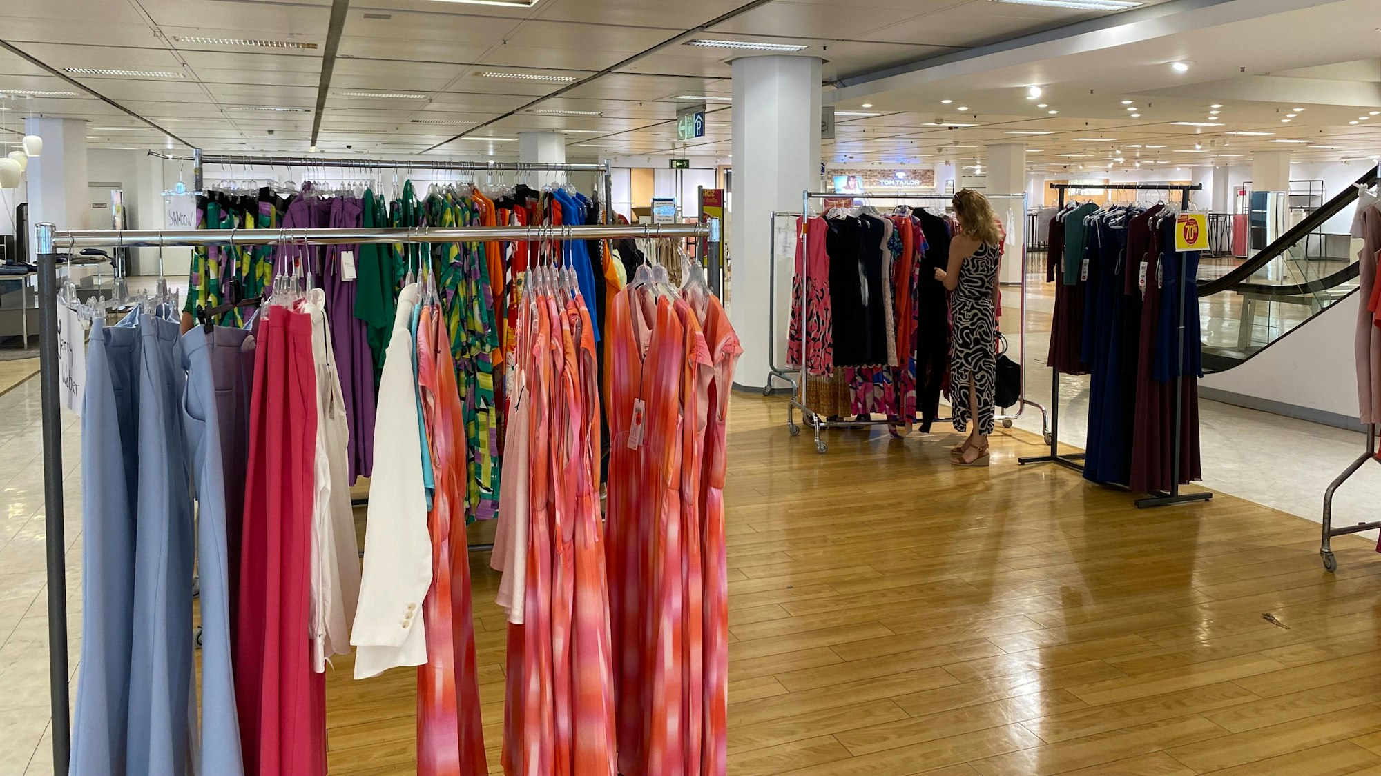 Auf dem Bild sind Verkaufsständer mit Kleidung zu sehen.