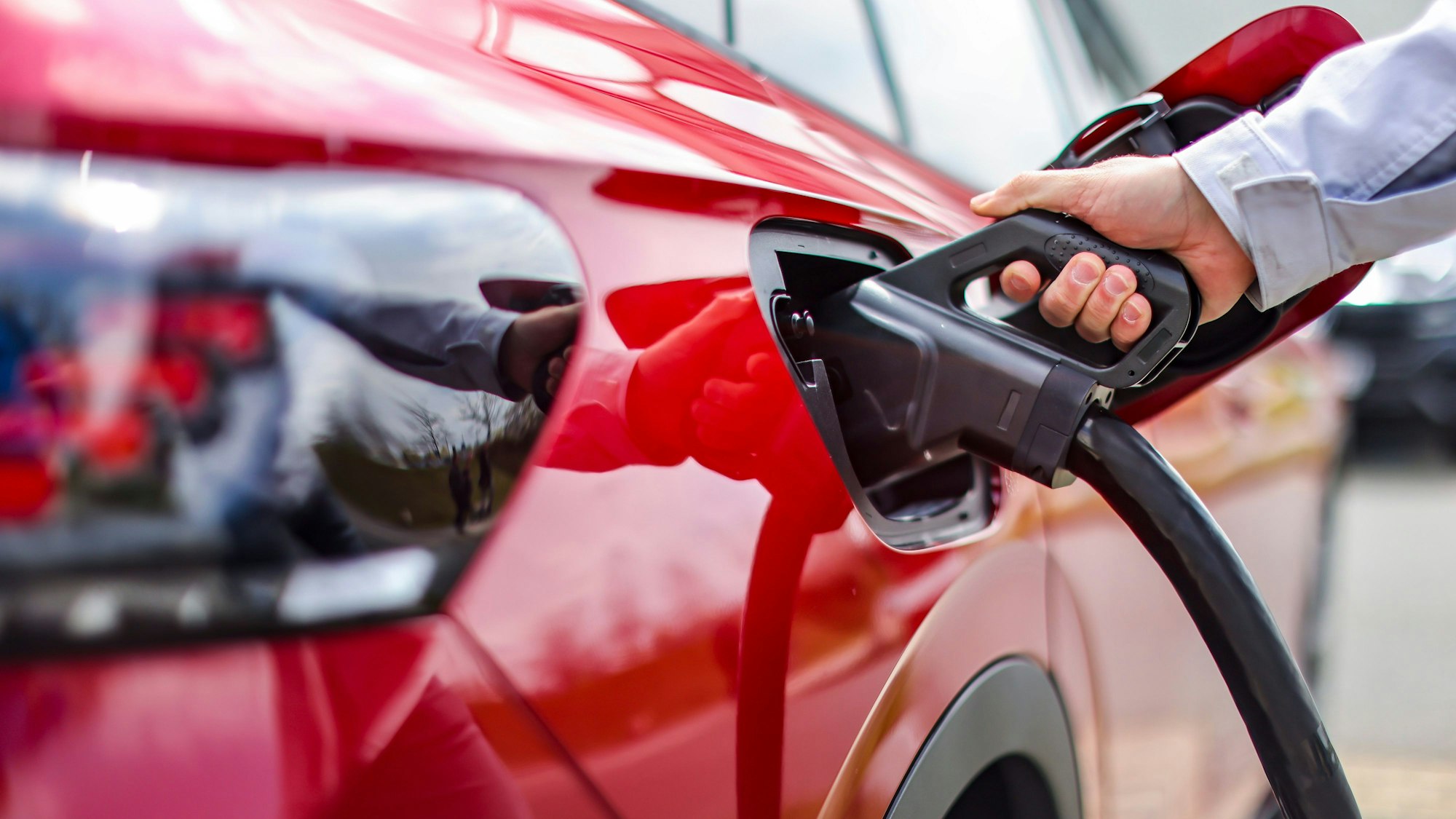 Ein rotes E-Auto wird aufgeladen.