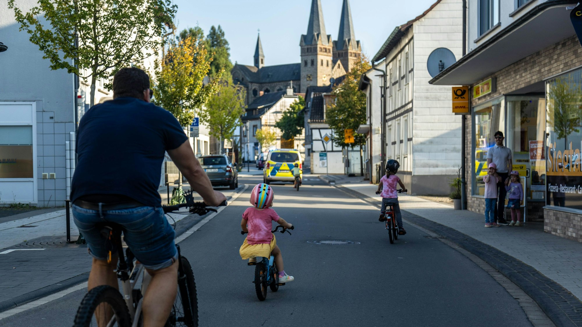 Mutig mitten auf der Straße: Das können kleine Radfahrer nur in Polizeibegleitung, so wie bei der Kiddical Mass in Windeck mit Blick auf den Dattenfelder Dom.