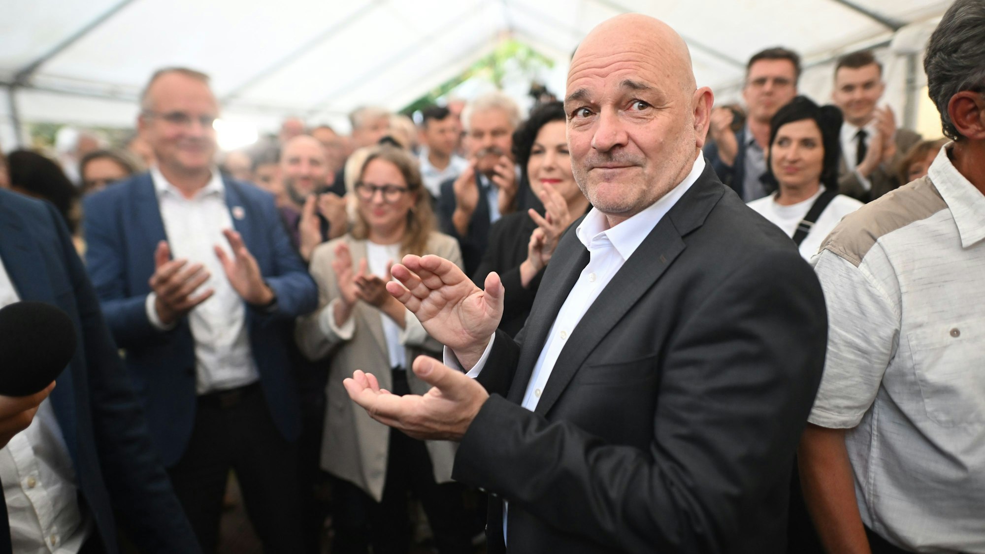 Robert Crumbach (r), Spitzenkandidat des Bündnis Sahra Wagenknecht (BSW) in Brandenburg, und andere Teilnehmer applaudieren während der Wahlparty des BSW.