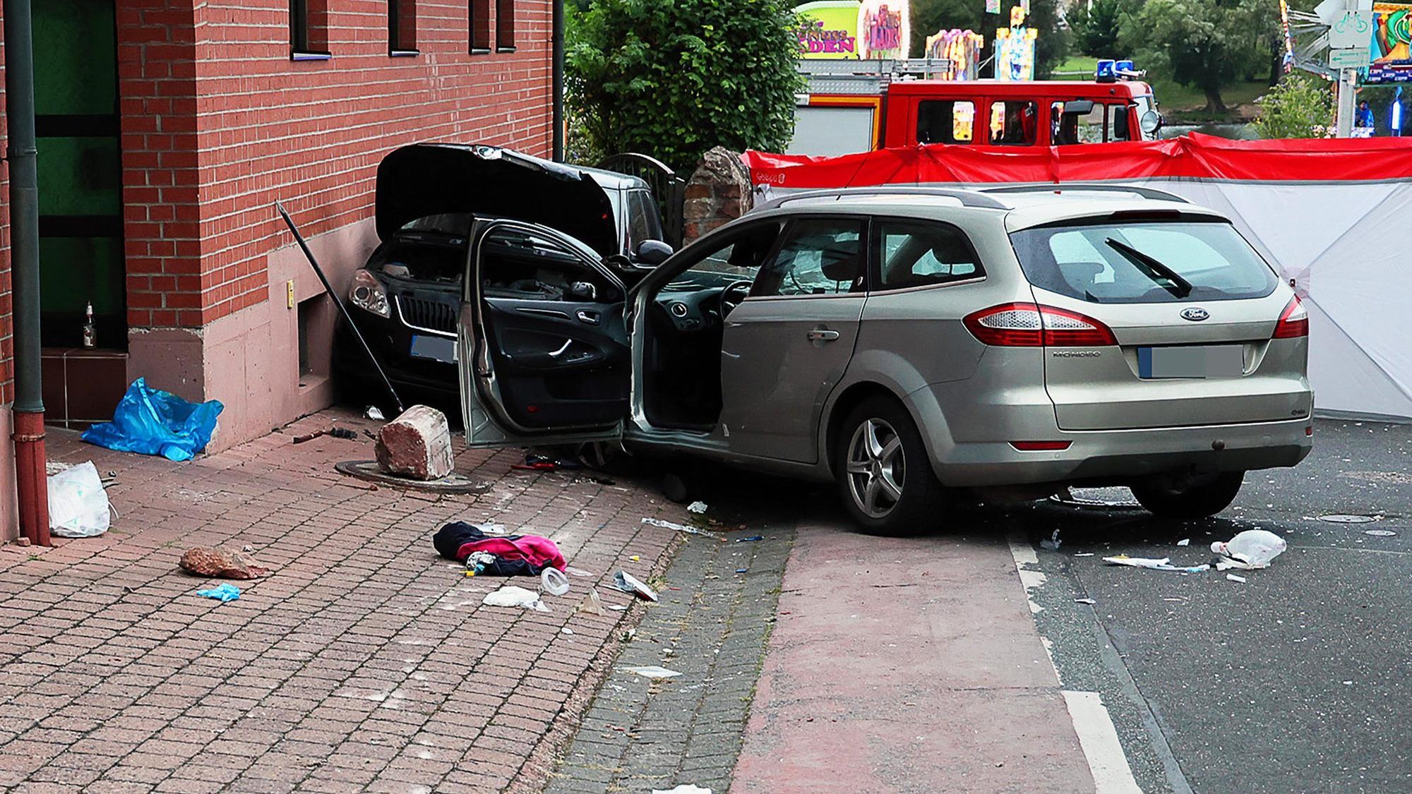 Zwei Fahrzeuge stehen im unterfränkischen Landkreis Miltenberg an der Unfallstelle. Ein Autofahrer ist auf der Kerb in eine Gruppe feiernder Menschen auf dem Fußweg gefahren.
