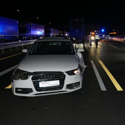 Ein beschädigtes weißes Auto auf einer Autobahn.