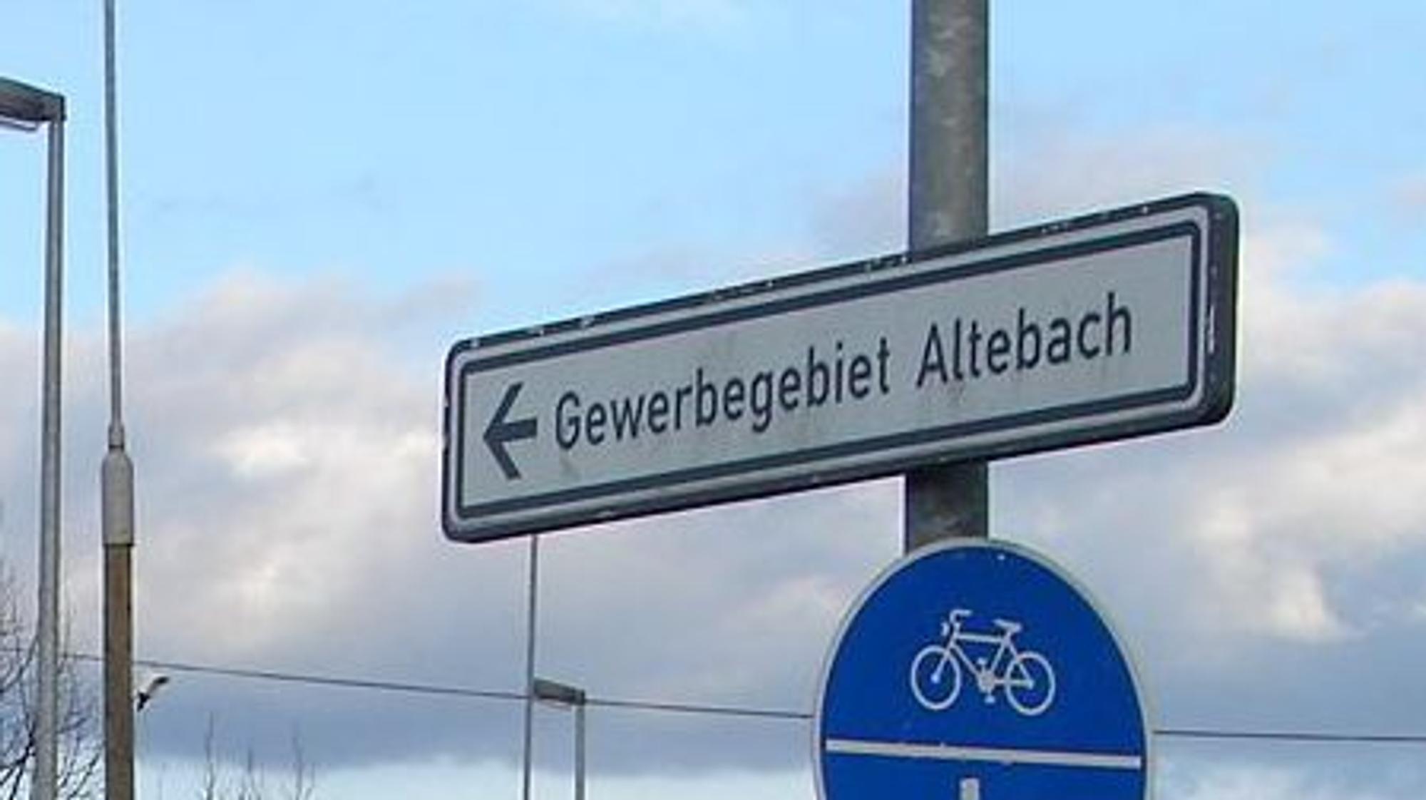 Ein Schild an einem Laternenmast weist den Weg ins Gewerbegebiet Altebach.