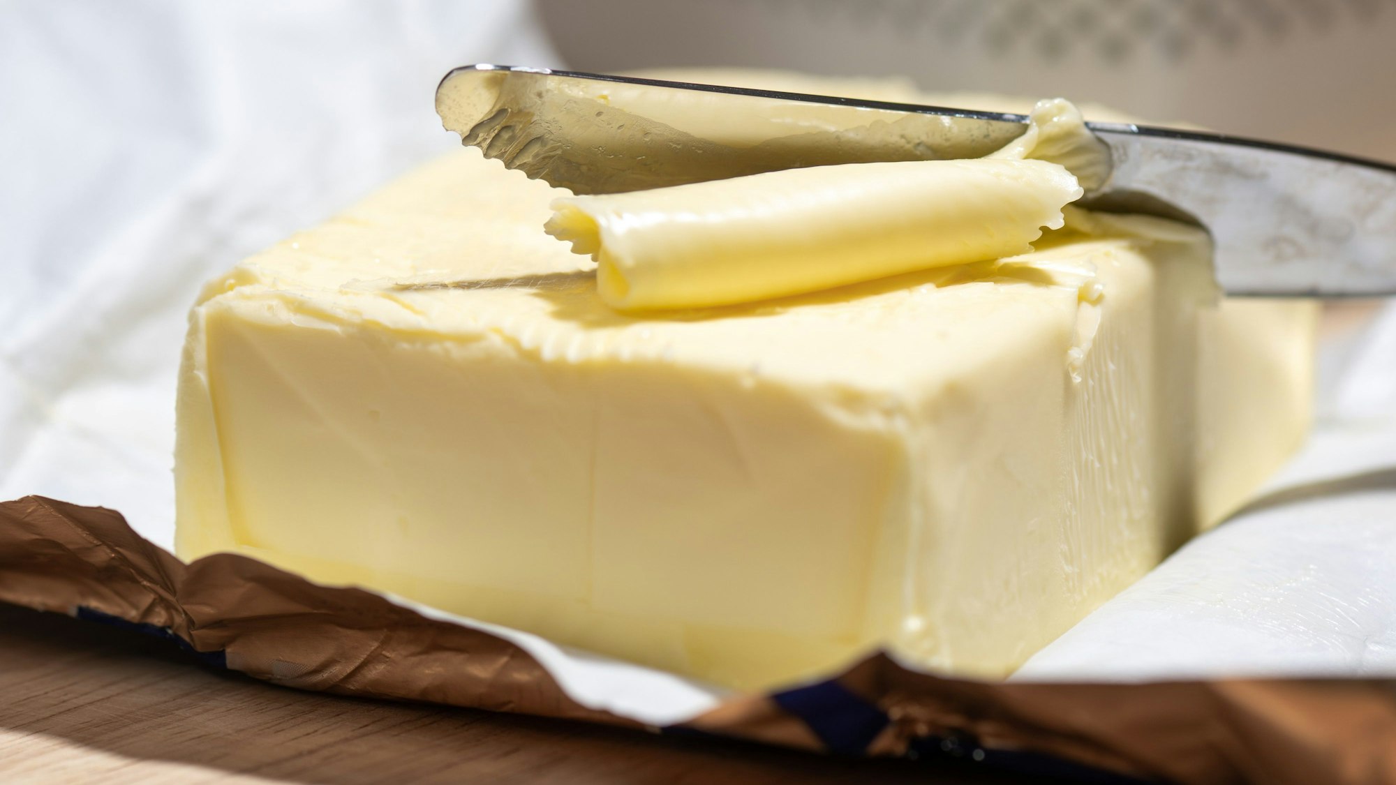 Ein Stück Butter liegt auf einem Tisch. (Archivbild)