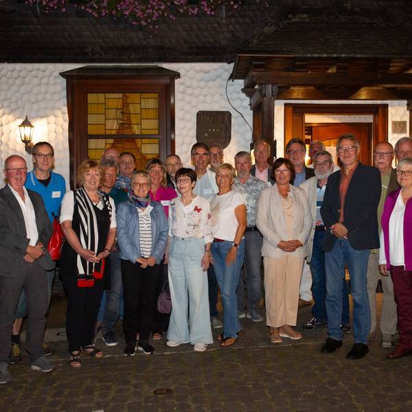 Eine Gruppe Männer und Frauen steht zum Foto aufgestellt vor dem Eingang des Restaurants Feste Neustadt.