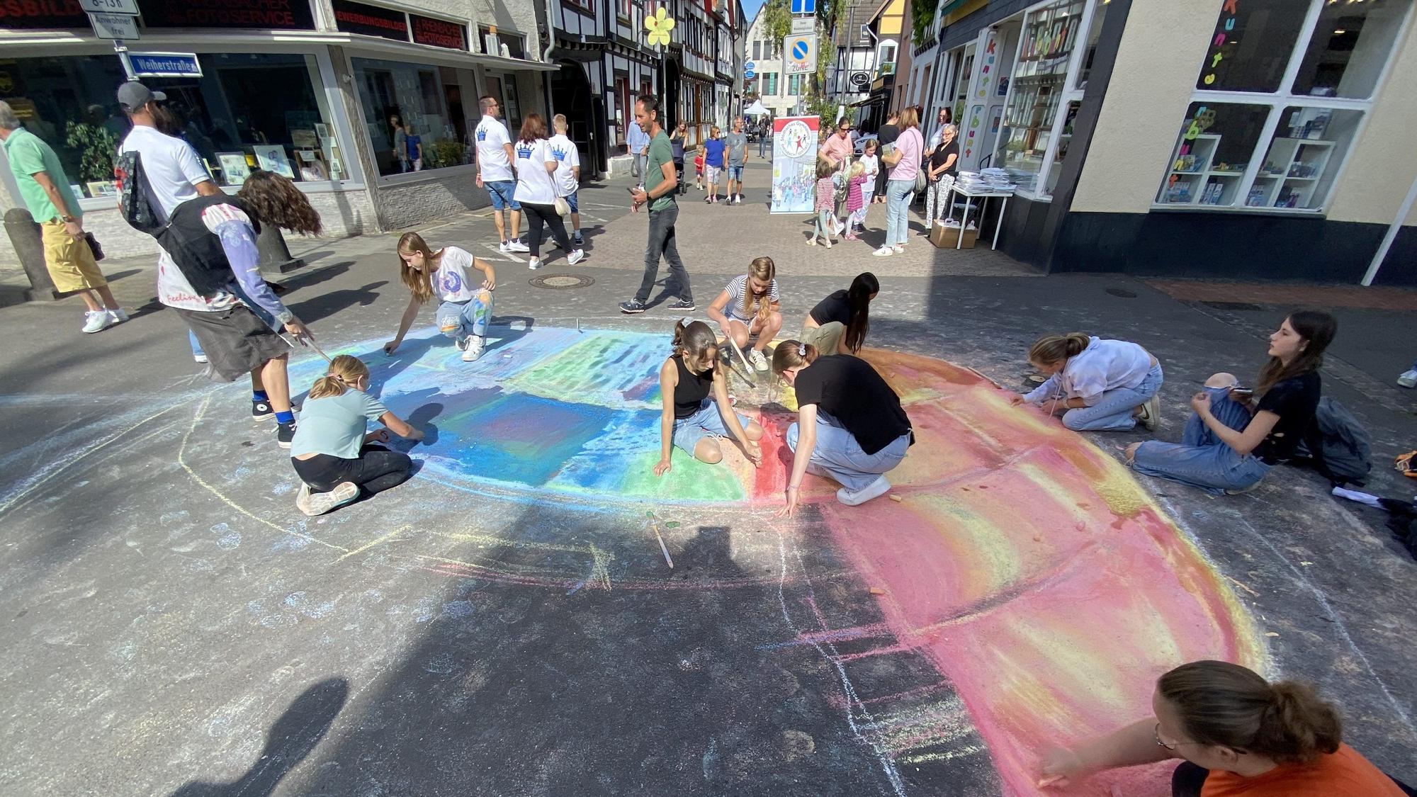 Die Kunstklasse von Lehrer Mert Yagmur lässt in der Weiherstraße mit Kreide und Wasser das römische Colosseum entstehen.