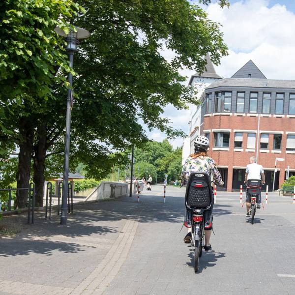 Eine Radfahrerin auf der Rheinpromenade