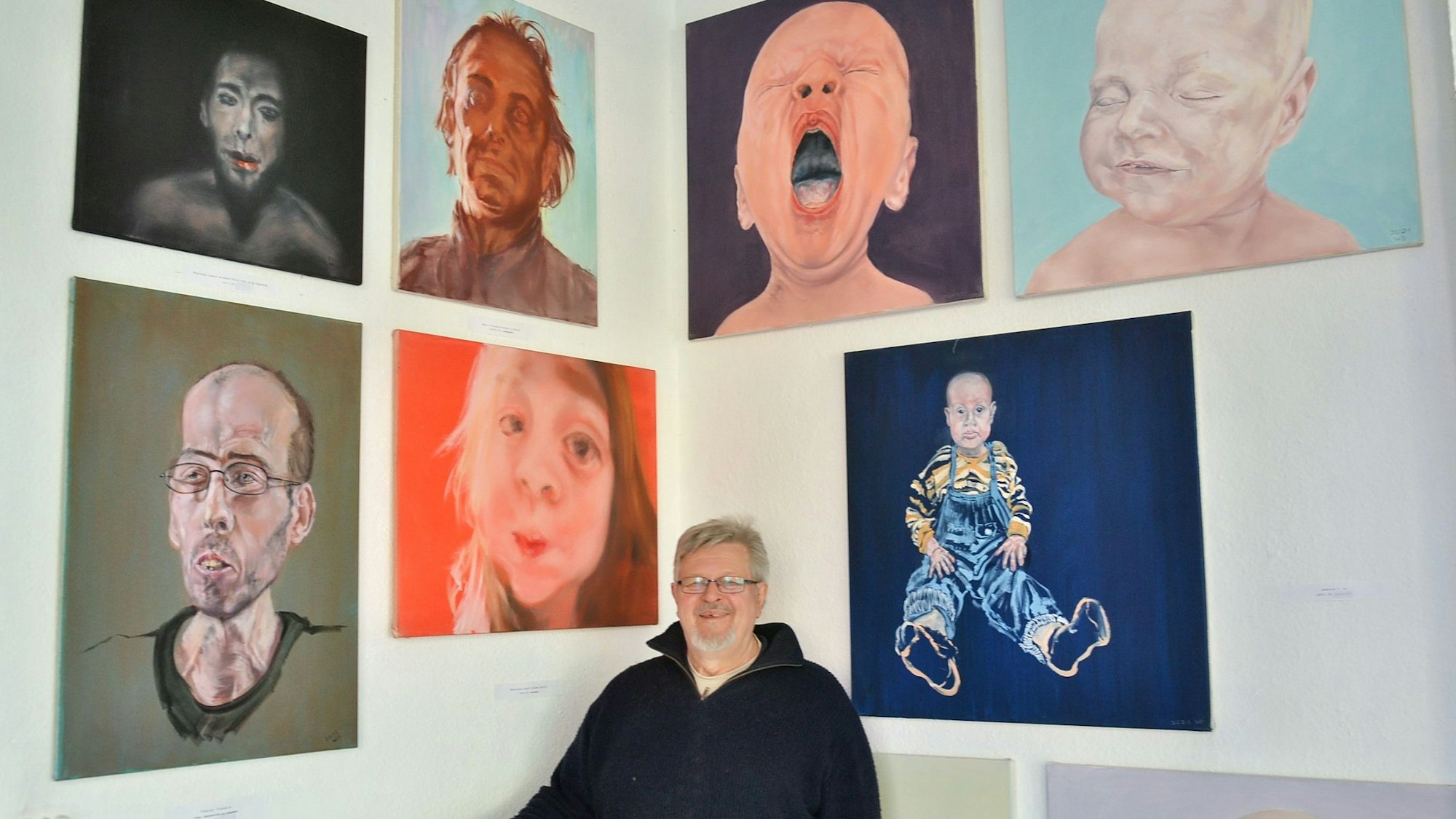 Rüdiger Axel Westphal steht in einer Ecke des FzKKE in Euskirchen. An den Wänden hängen Bilder des Künstlers Winfried Demhartner.