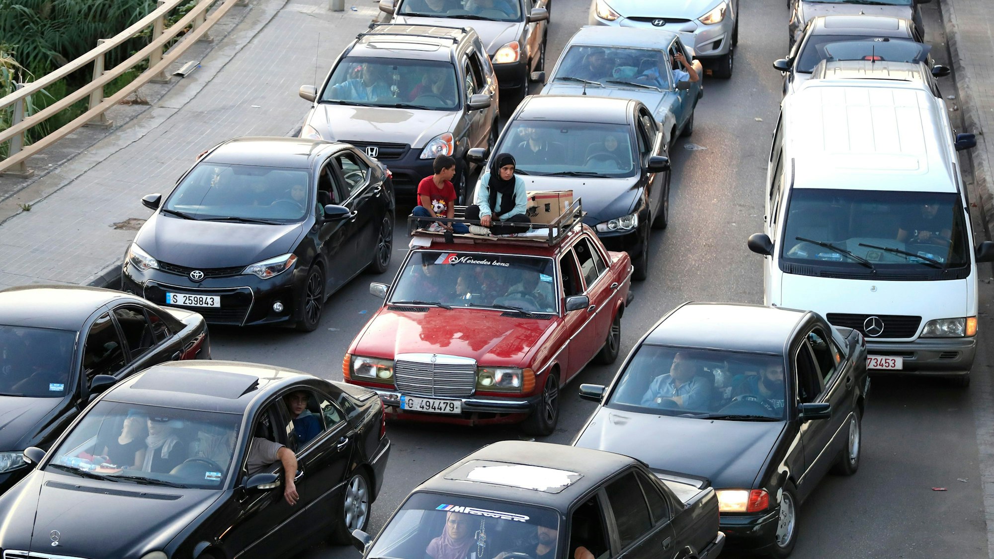 Libanon, Sidon: Menschen, die am Montag vor den anhaltenden israelischen Luftangriffen aus den südlichen Dörfern geflohen sind, sitzen in ihren Autos, während sie auf einer Autobahn, die nach Beirut führt, in der Hafenstadt Sidon im Stau stehen.