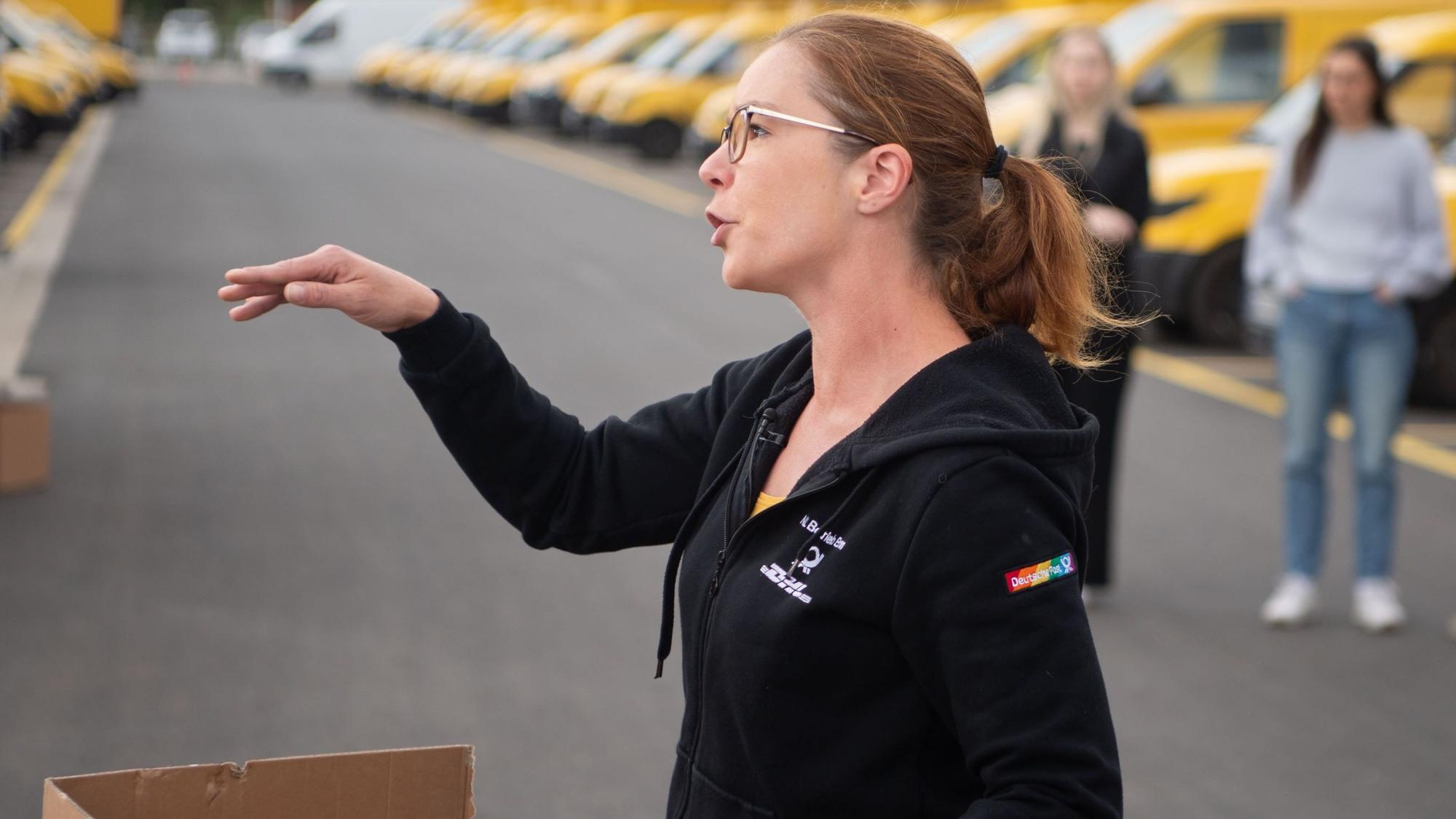 Sarah Schneider simuliert eine Paketzustellung.