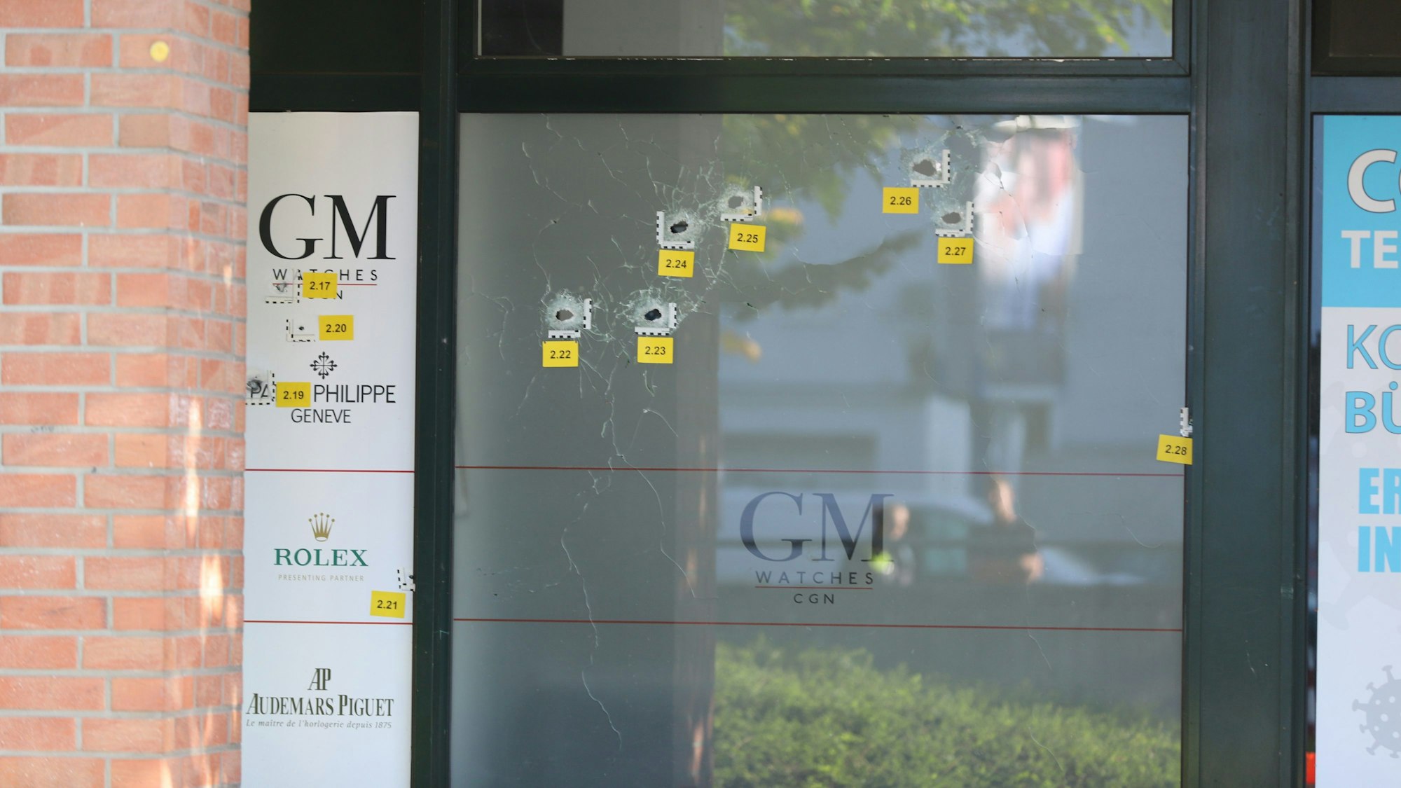 Einschusslöcher in der Fensterscheibe eines Uhrengeschäftes.