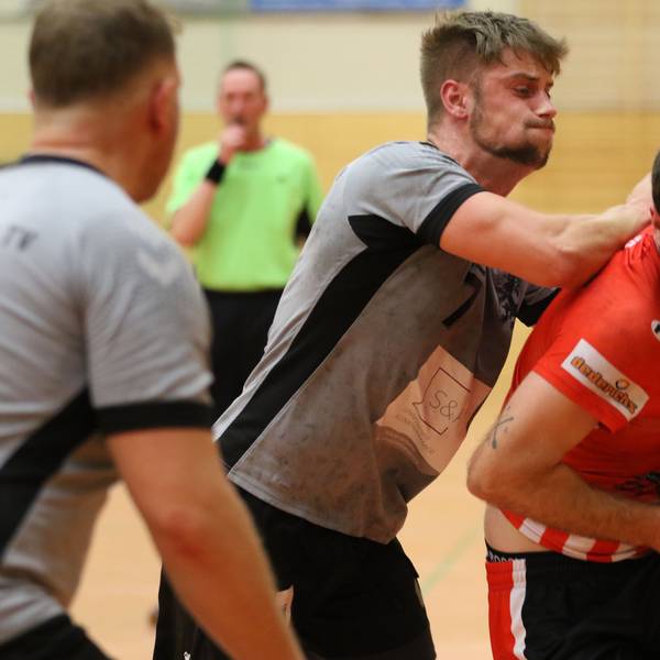 Euskirchens David Henzel hält den Ball vor seinem Bauch. Von hinten stößt ihn ein Gegenspieler mit dem Arm gegen den Rücken.