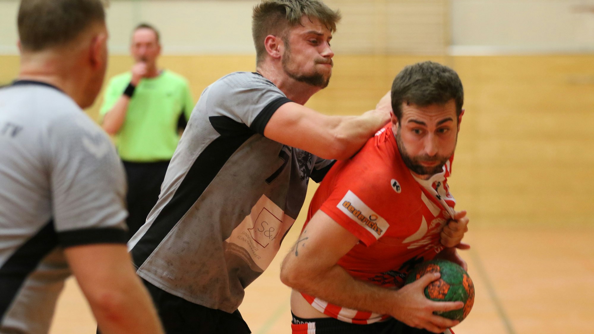 Euskirchens David Henzel hält den Ball vor seinem Bauch. Von hinten stößt ihn ein Gegenspieler mit dem Arm gegen den Rücken.