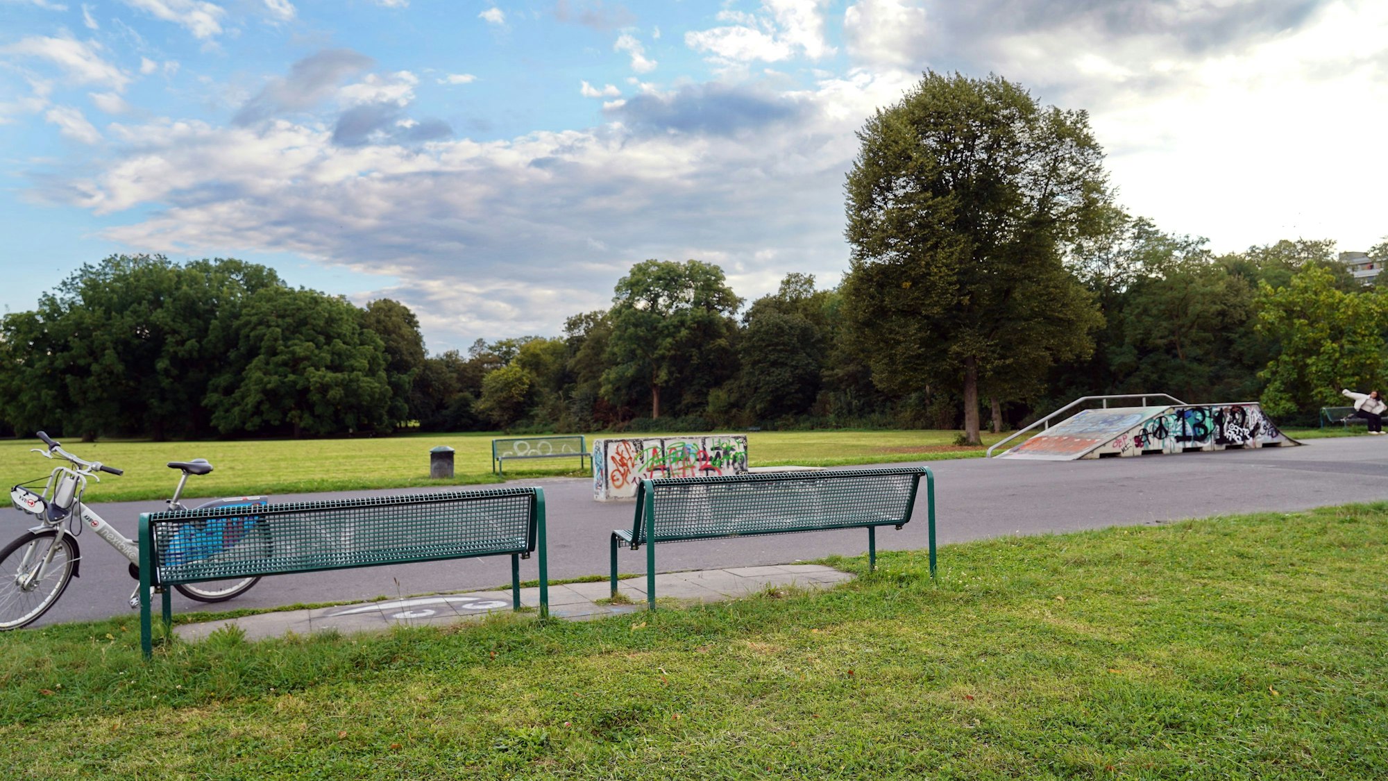 Zu sehen ist der kleine Skaterpark und Sitzbänke im Vorgebirgspark in Zollstock.