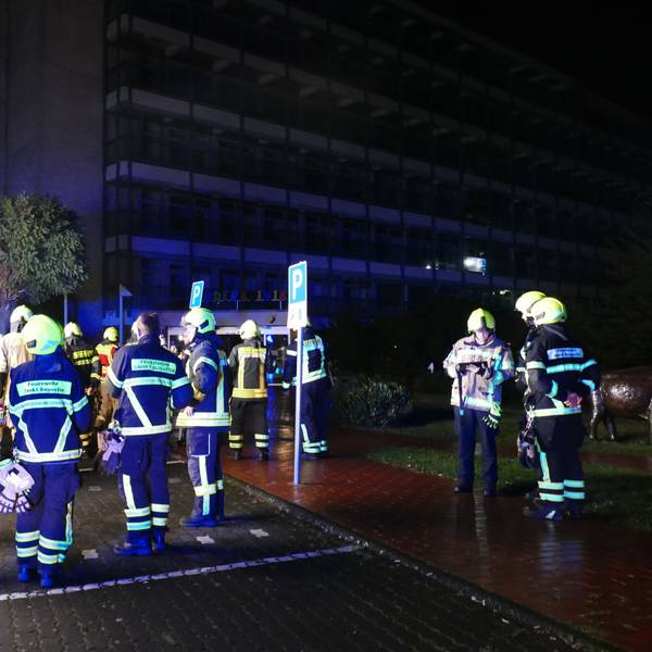 Feuerwehrleute stehen vor der dunklen Sankt Augustiner Kinderklinik.