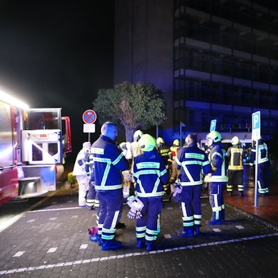 Feuerwehrleute stehen vor der dunklen Sankt Augustiner Kinderklinik.