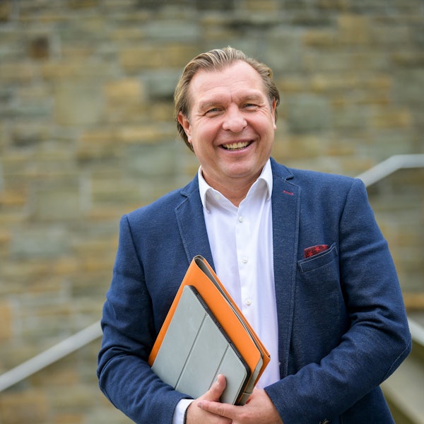 Ein Mann lächelt in die Kamera.