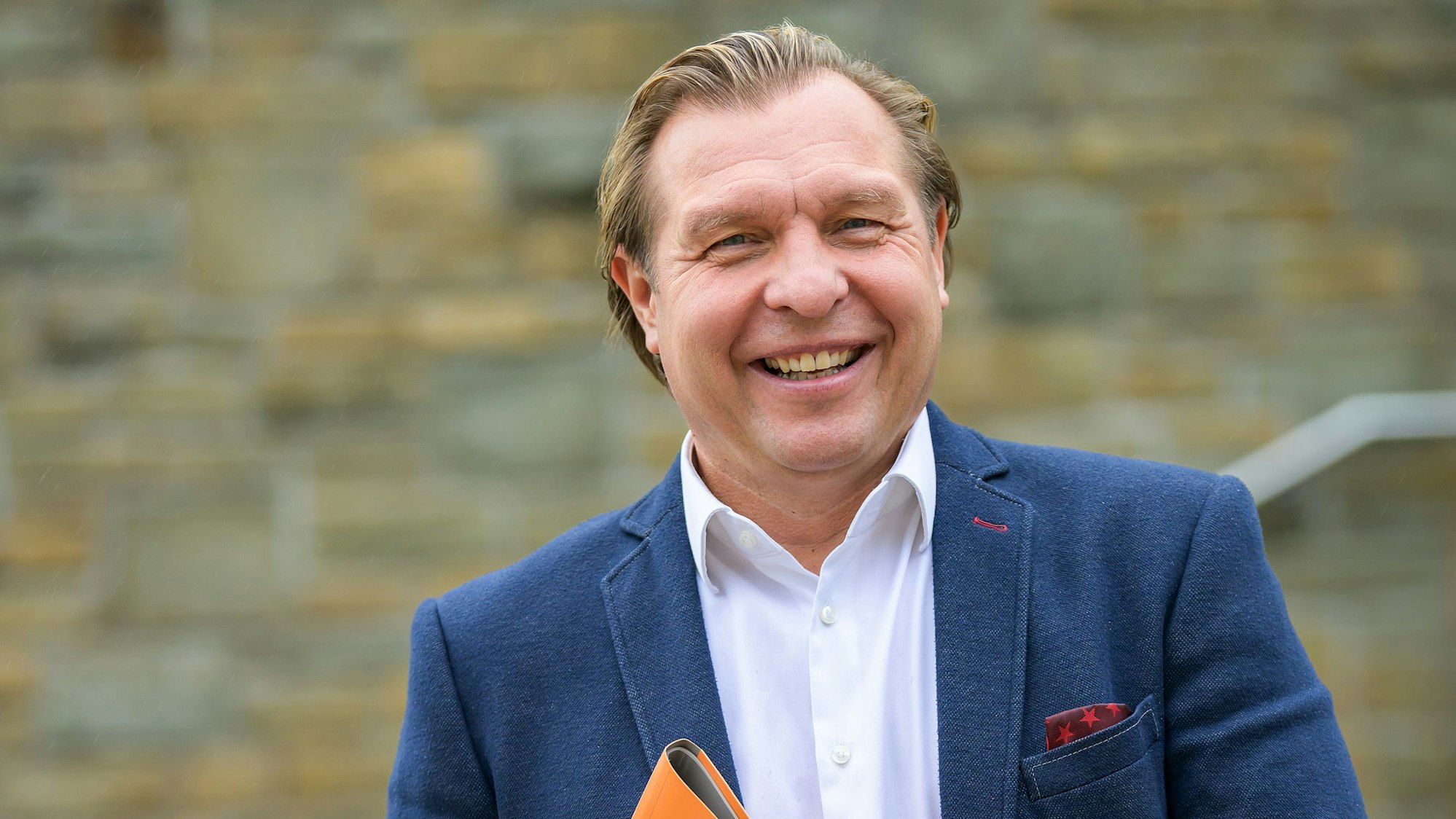 Ein Mann lächelt in die Kamera.