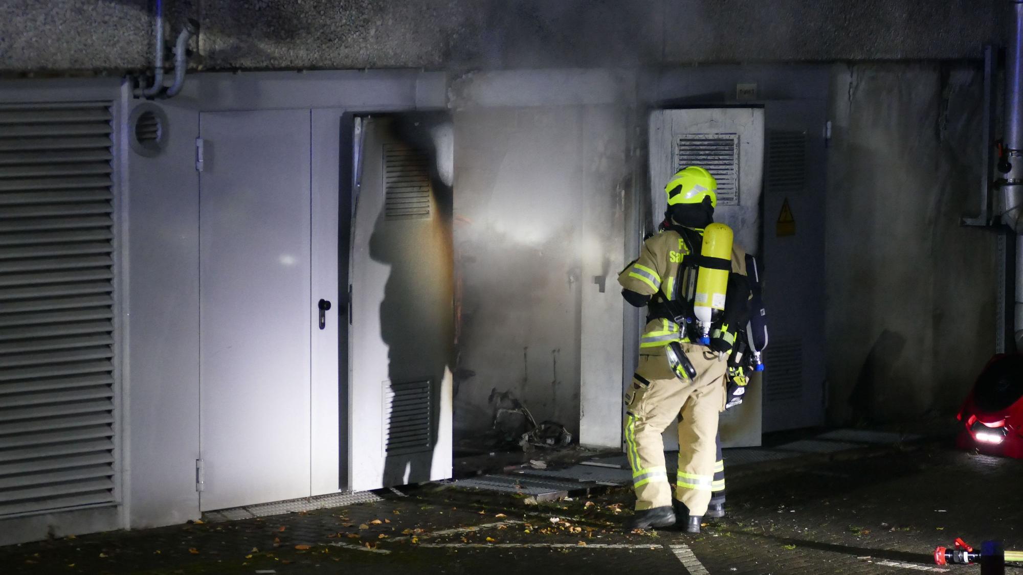 Ein Feuerwehrmann vor einer verrauchten Tür.