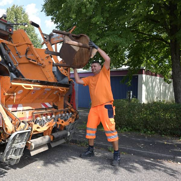 Das Foto zeigt einen Mitarbeiter der Müllabfuhr bei der Arbeit