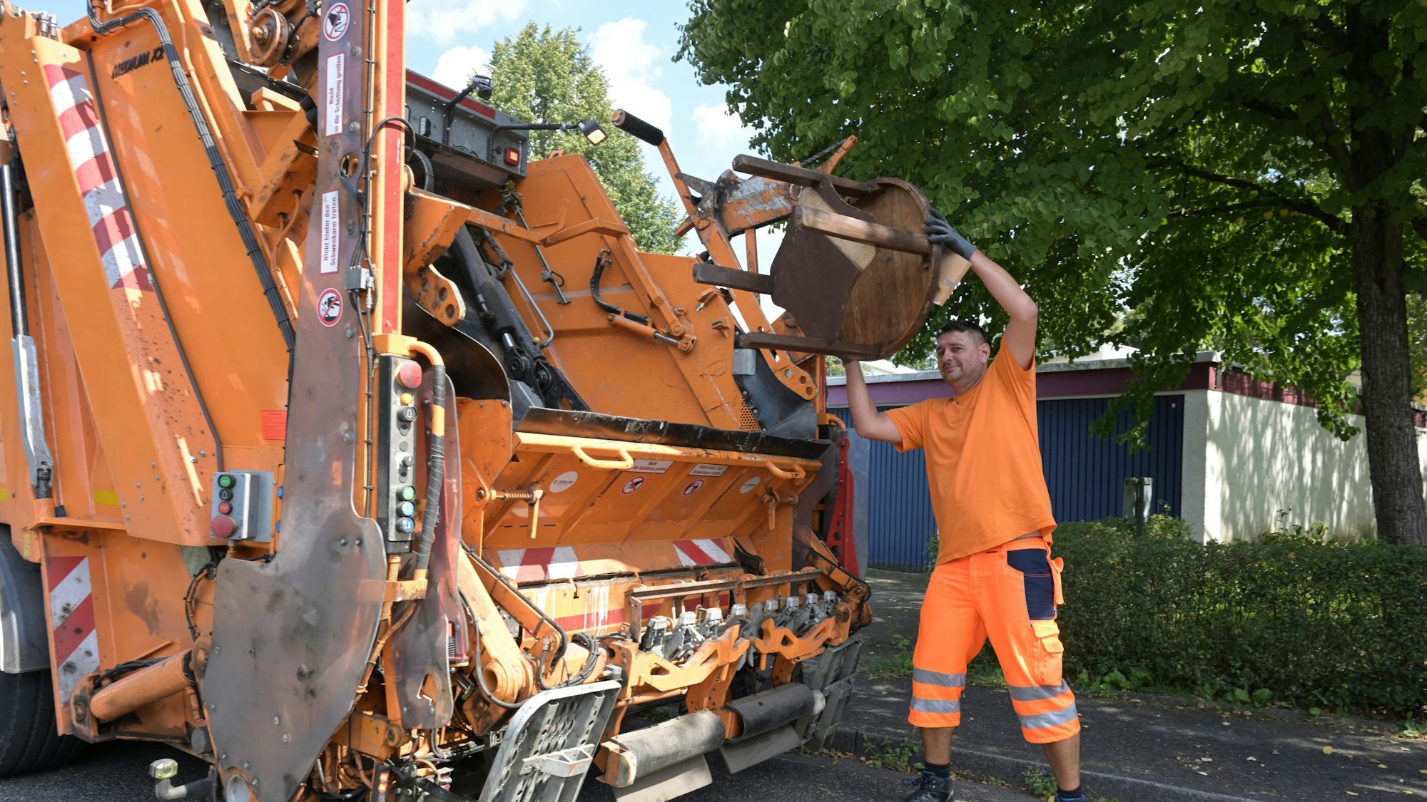 Das Foto zeigt einen Mitarbeiter der Müllabfuhr bei der Arbeit