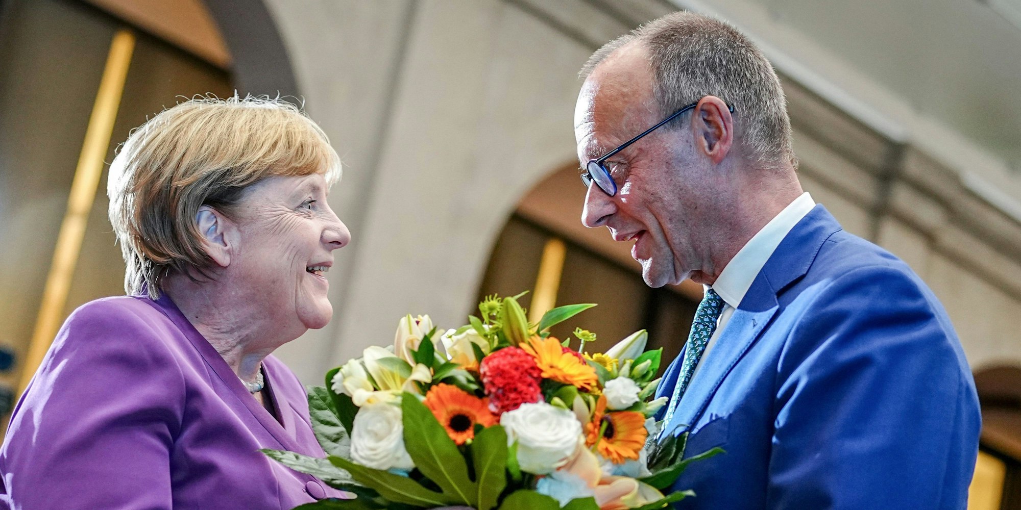 Berlin: Friedrich Merz, CDU-Bundesvorsitzender und Unionsfraktionsvorsitzender, überreicht Angela Merkel beim Berliner Gespräch Spezial zum 70. Geburtstag der früheren Bundeskanzlerin einen Blumenstrauß.